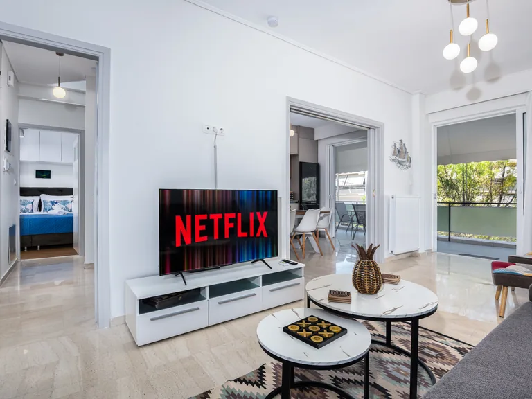 Bright contemporary living room at Amphitryon Residence with comfortable seating and balcony light.