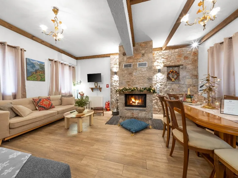 Villa Dianne 1 living room with stone fireplace, warm seating and mountain-style interior.