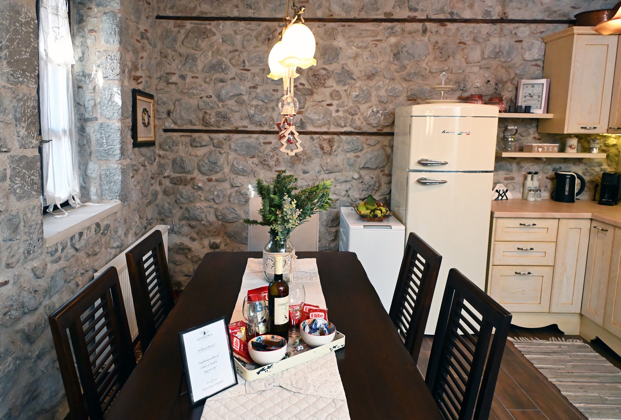 Dining table set near the kitchen and stone walls.
