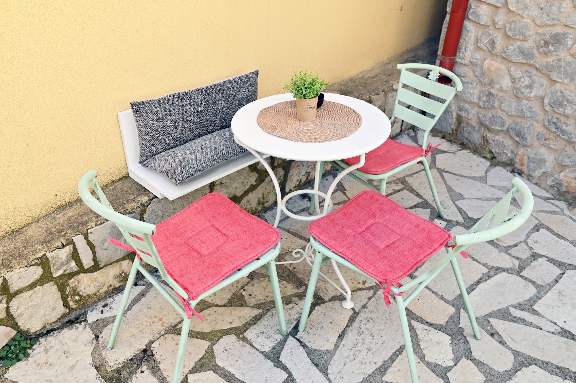 Small outdoor dining table and chairs in the stone courtyard.